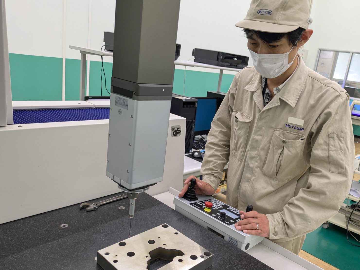 三次元測定機を操作し、製品の仕上がりを検査する様子