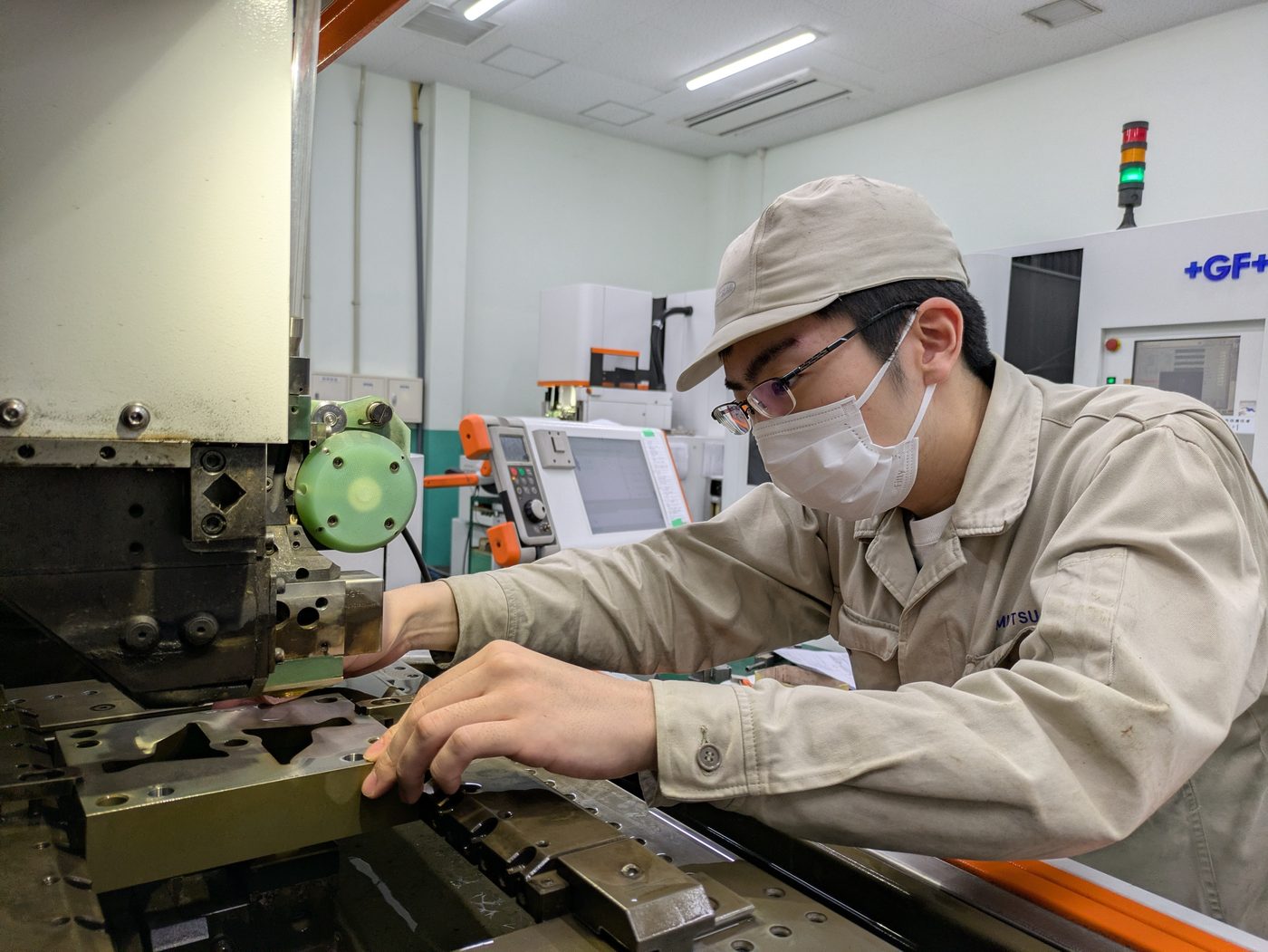 工作機械で部品を加工する社員